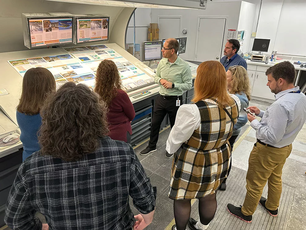 group of people in front of a press proofing station