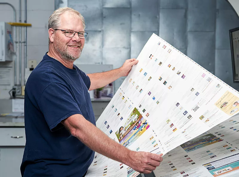 Friesens employee holding up print spread
