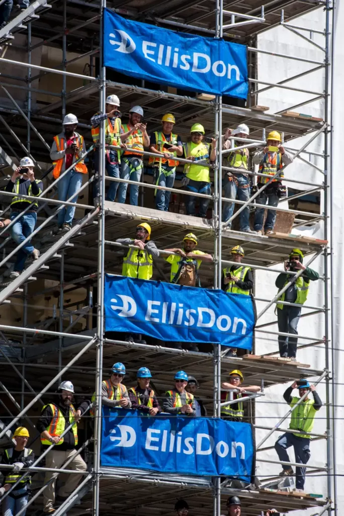 Image of employees gathered on scaffolding with EllisDon banners
