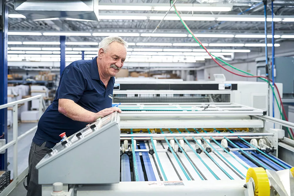 Mail employee looking over machine